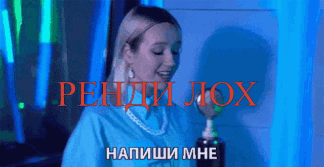 a woman in a blue shirt is singing into a microphone in front of a sign that says " rehti lox "