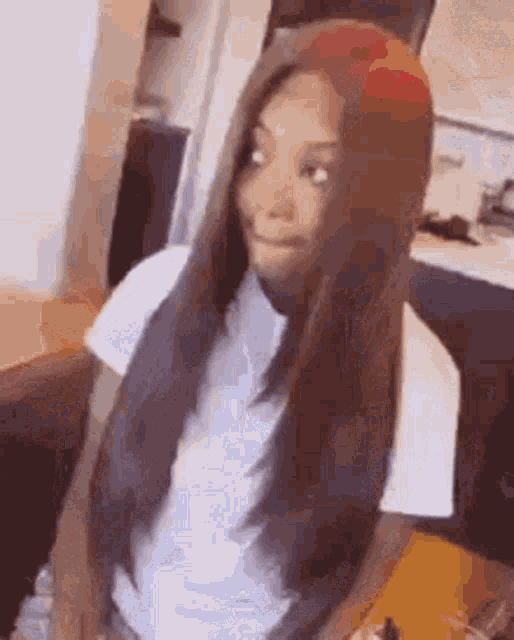 a woman with long hair is making a funny face in a room .