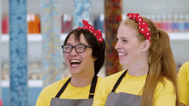 a man and a woman wearing yellow shirts and aprons are laughing together