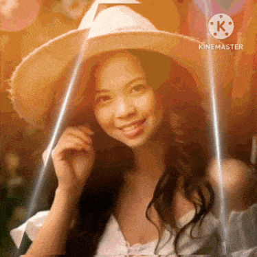 a woman wearing a straw hat and a white dress is smiling in front of a screen that says kinemaster