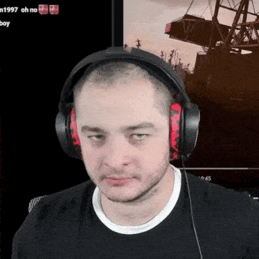 a man wearing headphones looks at the camera in front of a screen that says 1997 oh no boy