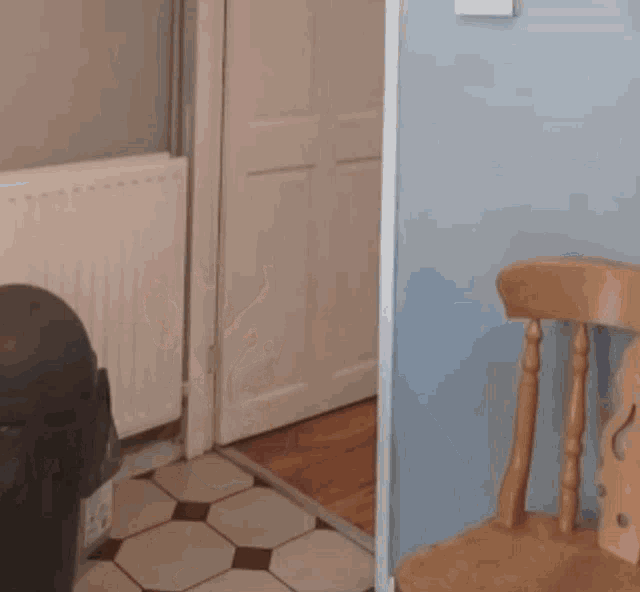 a wooden chair sits next to a trash can in a hallway