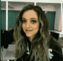 a woman with long green hair is smiling and making a funny face .
