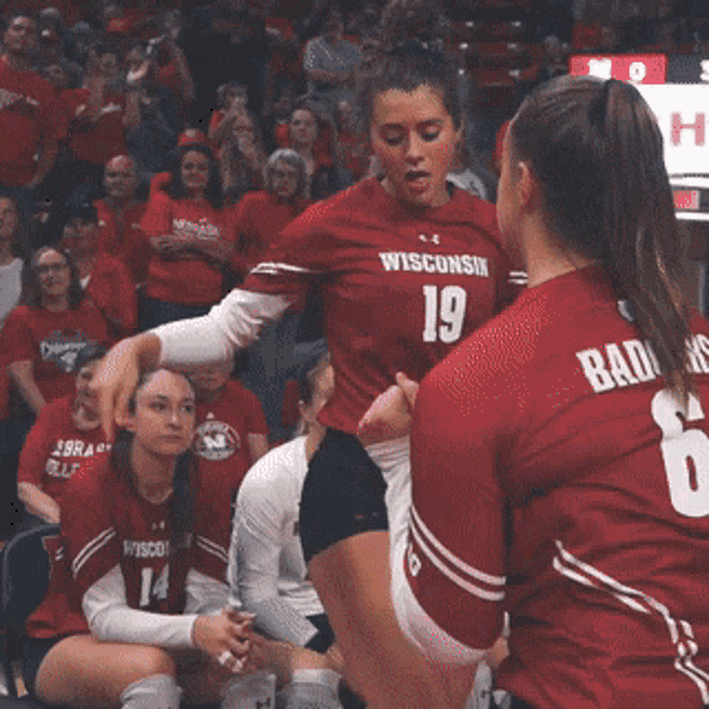 two female volleyball players from wisconsin are talking to each other