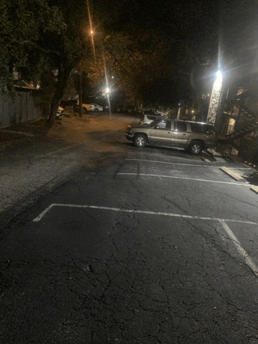 a silver suv is parked in a dark parking lot