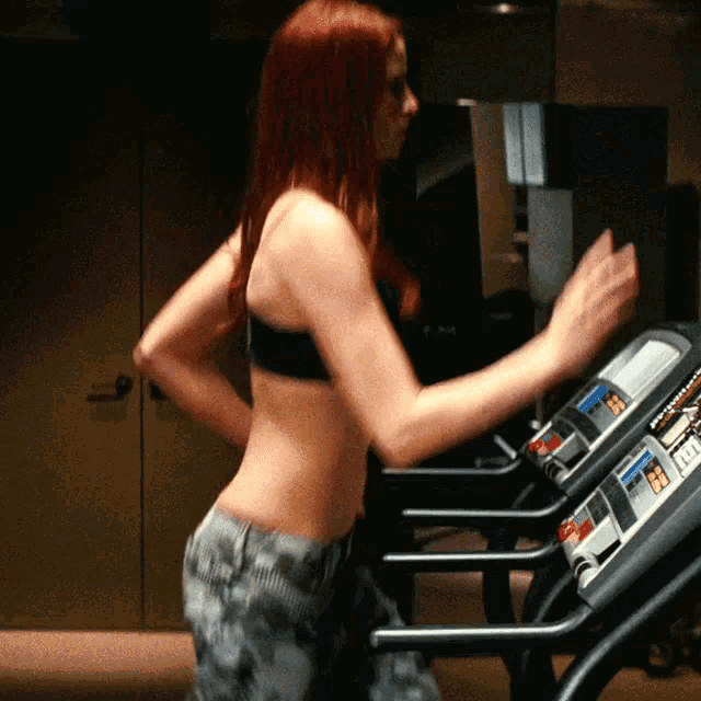a woman in a black bra is running on a treadmill with a few buttons