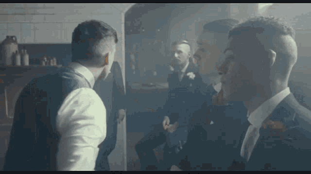a group of men in suits are standing in a room with smoke coming out of it