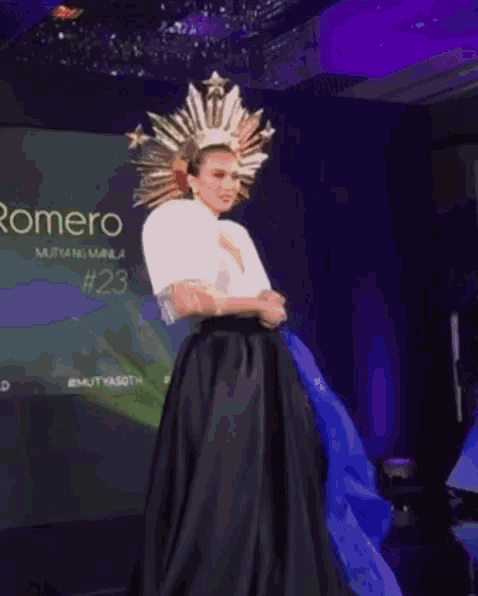a woman in a black and white dress is dancing in front of a screen that says omero # 2