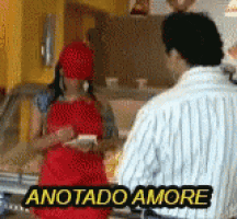 a woman in a red apron is talking to a man in a striped shirt who says anotado amore