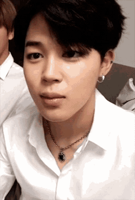 a close up of a person wearing a white shirt and necklace .