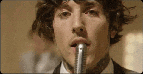 a close up of a man singing into a microphone .