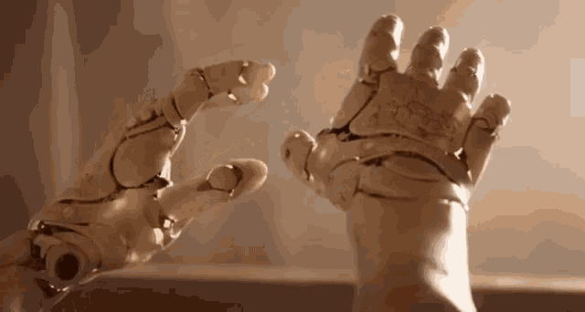 a close up of a robot 's hands reaching out towards each other .