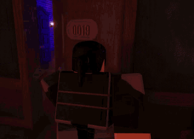 a person standing in a dark room with a chandelier behind them that says 00 on it