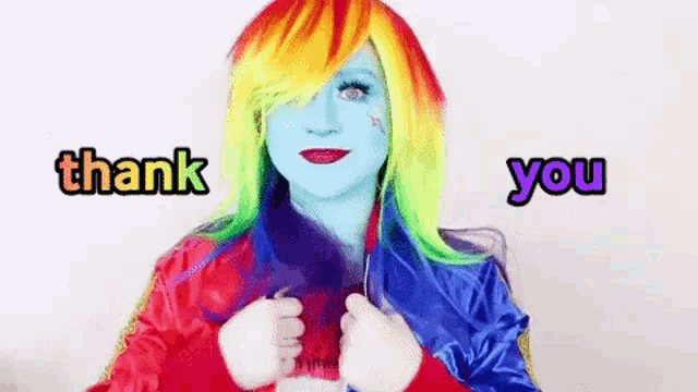 a woman in a rainbow dash costume is giving a thank you sign .