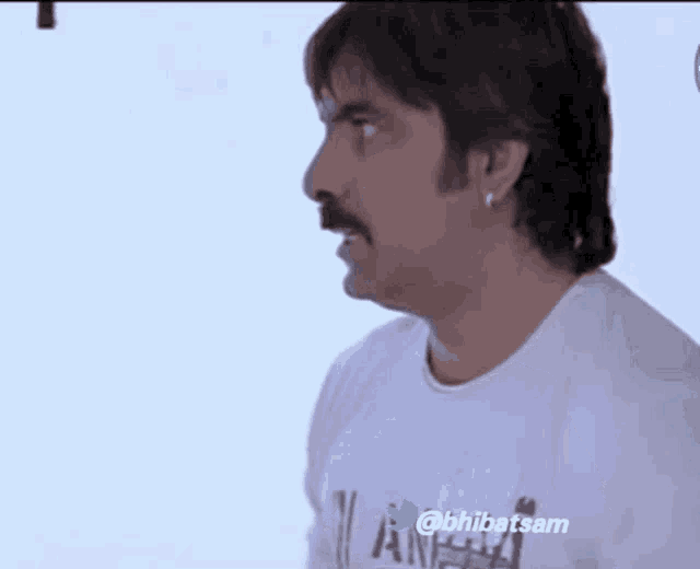 a man with a mustache is wearing a white shirt that says angels
