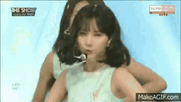 a girl in a white dress is singing into a microphone on the show .