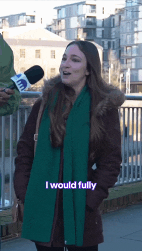 a woman wearing a green scarf is talking into a microphone with the words i would fully below her