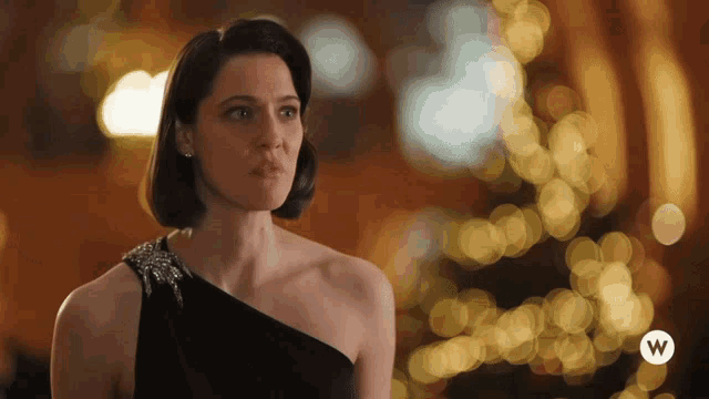 a woman in a black dress with the letter w on the bottom