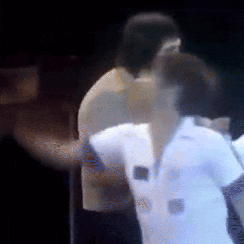 a man in a white shirt is standing next to another man in a white shirt .