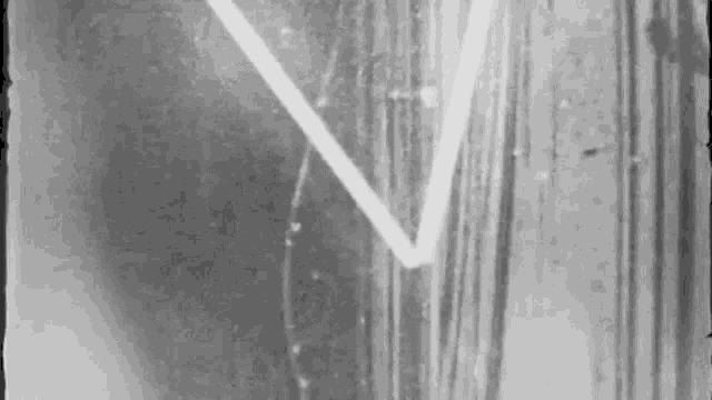 a black and white photo of a wall with a triangle drawn on it