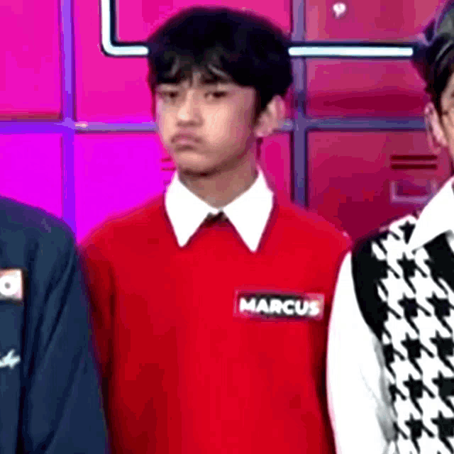 a young boy in a red sweater with the name marcus on it