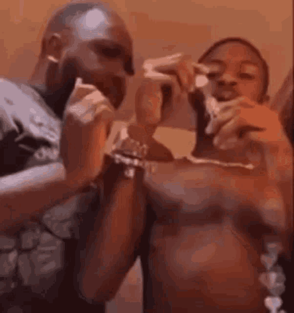 two men are standing next to each other eating ice cream .