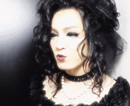 a woman wearing a black dress and a choker necklace