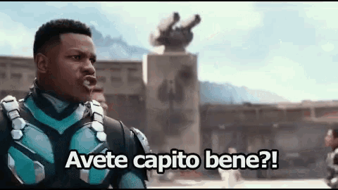 a man in a superhero costume is making a funny face and says avete capito bene .