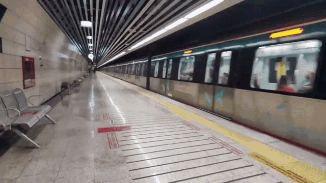 a subway train is pulling into a station with a sign on the floor that says " do not enter "