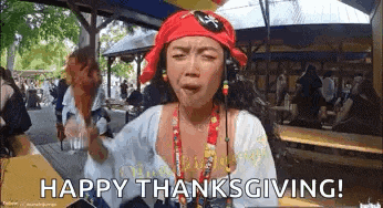 a woman dressed as a pirate is holding a chicken leg and says happy thanksgiving .