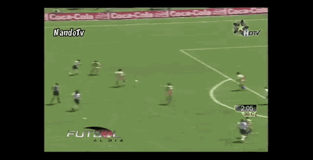 a soccer game is being played on a field with coca-cola advertisements