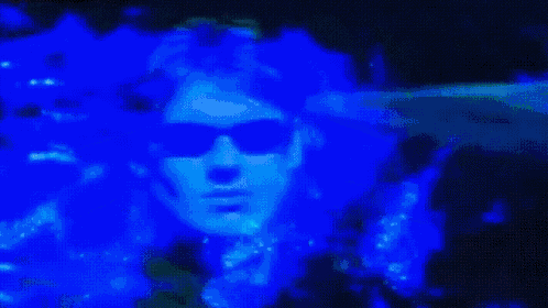 a close up of a person wearing sunglasses in a dark room