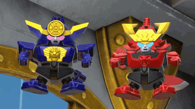 two toy robots are standing next to each other on a ledge
