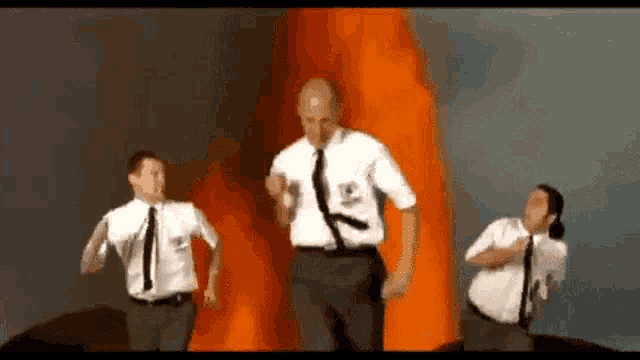 a man in a white shirt and tie is running in front of a volcano erupting