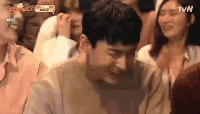 a man is laughing in a crowd with tvn written on the bottom of the screen
