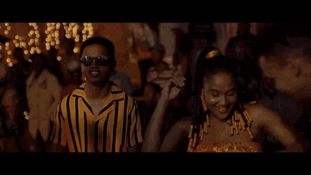 a man and a woman are dancing in a crowd at a party