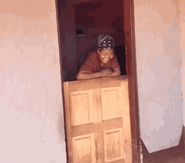 a woman is standing in a doorway looking out .