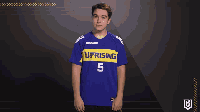 a young man wearing a blue uprising jersey number 5