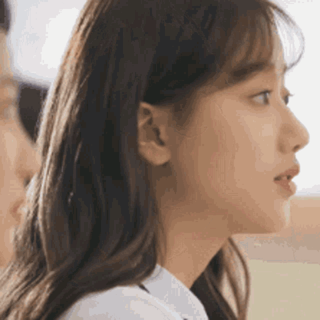 a close up of a woman 's face with a man behind her .