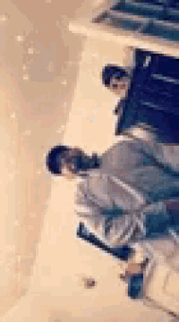 a man is sitting on a chair in a room with a reflection of him in the mirror .