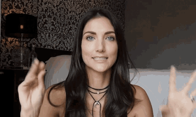 a woman with braces on her teeth is smiling and giving the peace sign