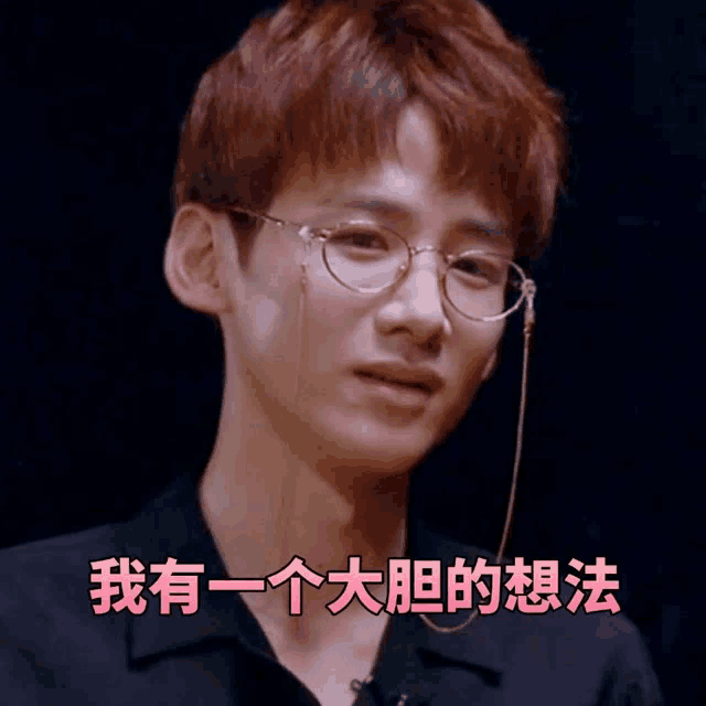 a man wearing glasses with a chain around his neck