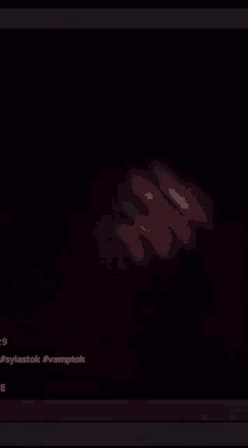 a close up of a person 's hand in the dark with a black background .