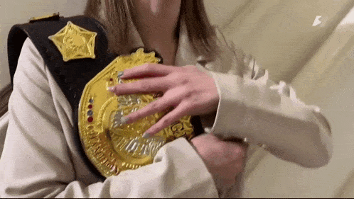 a woman is holding a wrestling belt around her neck .