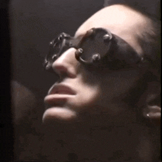 a close up of a person wearing sunglasses and earrings