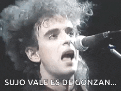 a man with curly hair is singing into a microphone in a black and white photo .