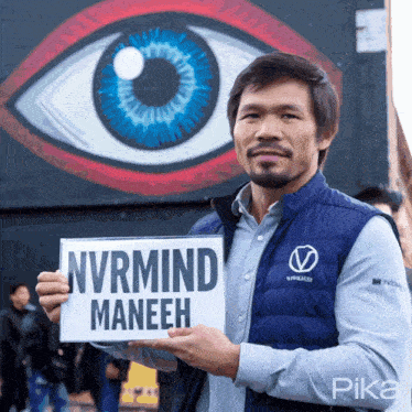 a man in a blue vest holds up a sign that says nvrmind maneeh
