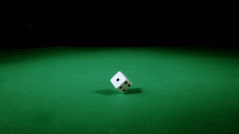 a group of dice are falling on a green table and one of them has the number six on it