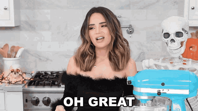 a woman standing next to a blue kitchenaid mixer says " oh great "