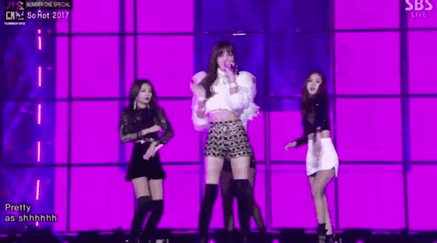 a group of girls are standing on a stage .
